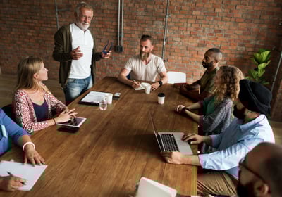 a group of office workers sitting around a table for training