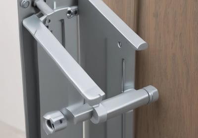 A modern elevator is centered between illuminated panels with a minimalist, geometric design. The elevator doors are metallic and closed, with control buttons on either side. Above the doors, a display shows the number 3.