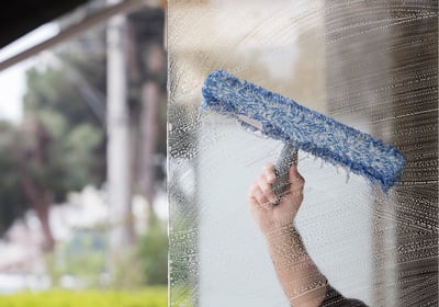 Technician from Like Glass cleaning glass with a squeegee in The Villages