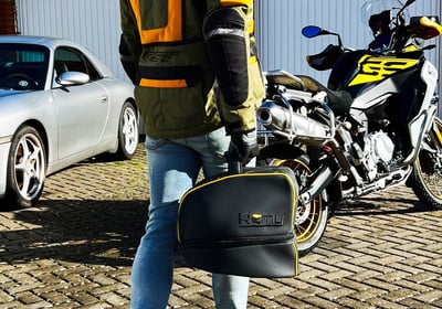 Remy helmet bag resting on a parked motorcycle, highlighting premium design and real-world use