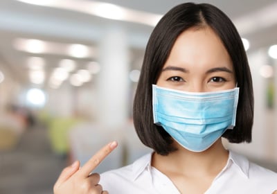 a woman in a white shirt and a blue mask mask