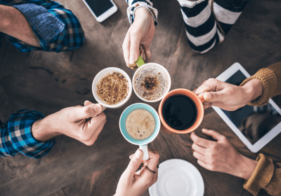 a group of people holding coffee cups and drinking coffee