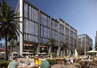 People enjoying outdoor dining at cafés beneath sleek office buildings at One Ninety, New Cairo.