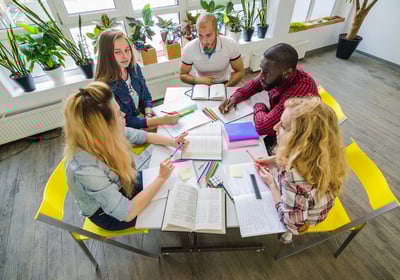 Groupe de personnes discutant autour d'une table lors d'une réunion.