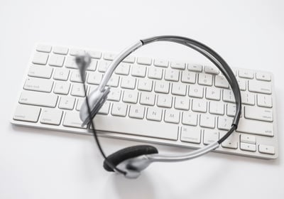 Casque audio avec micro posé sur un clavier d'ordinateur.