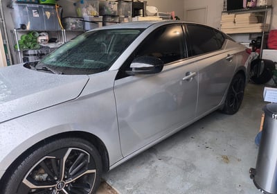 a car parked in a garage with a car in the background