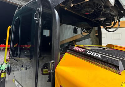 a yellow bulldozer is parked in a garage