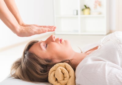 a woman is shown in a massage room sesiones de reiki