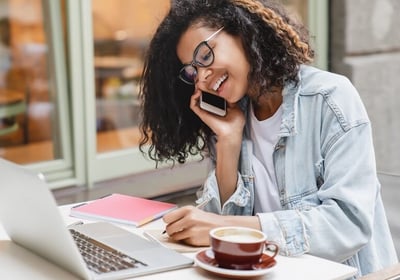 a woman sitting at a table with a laptop and a cup of coffee