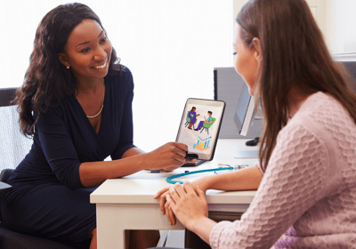 a woman with a laptop as a consultant to another woman sitting across from her