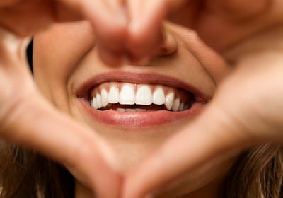 A confident person smiling after a complete smile makeover, featuring perfectly aligned and bright t