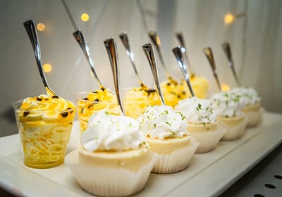 a row of desserts with spoons and spoons