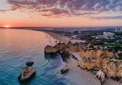 Golden cliffs and sandy beach of Alvor, Portugal, at sunset