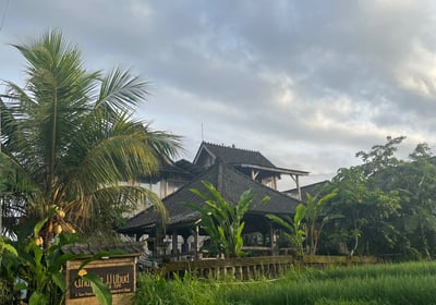 a house with a large field of grass and a house in the background