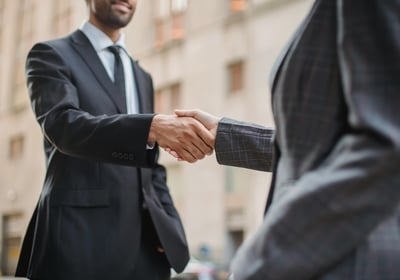 a man and woman shaking hands in a city