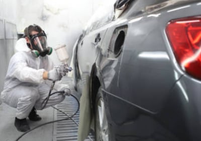 Un carrossier-peintre repeint un véhicule