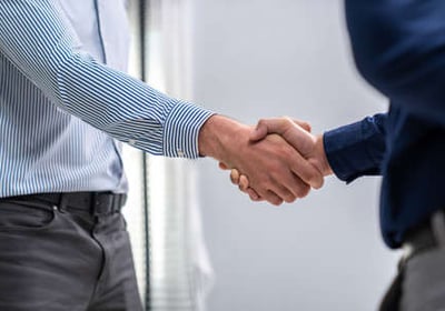 Gestión personalizada y negociación: dos personas sellando un acuerdo con un apretón de manos