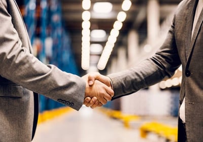 Handshake of two professionals in warehouse — symbolising trusted logistics partnerships in Qld.