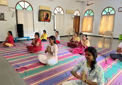 a group of people meditating on a rug in a room