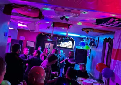 a group of people standing around a table with balloons