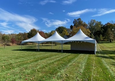 three white marquee tents on the grass