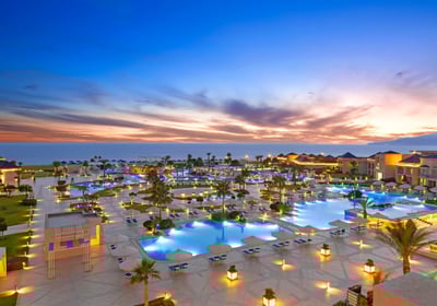 a beautiful hotel resort with a large pool with a view of the ocean