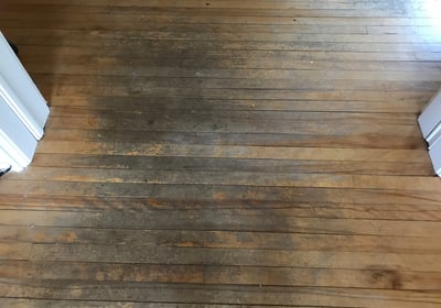 a worn discolored hardwood floor