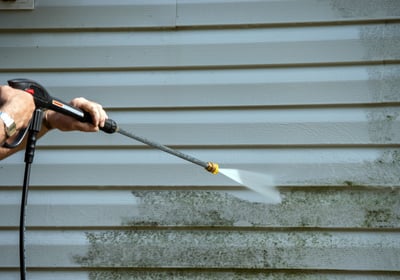 siding being cleaned by a pressure washer