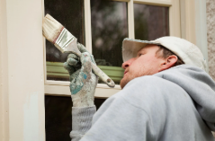 a man painting exterior trim