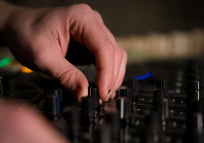 gros plan sur la main du DJ qui actionne un bouton sur sa platine