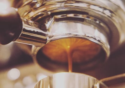 a naked portafilter is extracting a double shot of espresso