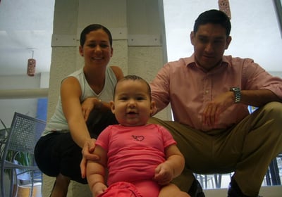 a man and woman sitting on a couch with a baby