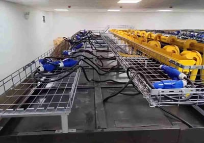 a bunch of cables lying in the wire mesh cable tray with yellow fiber plastic cable duct