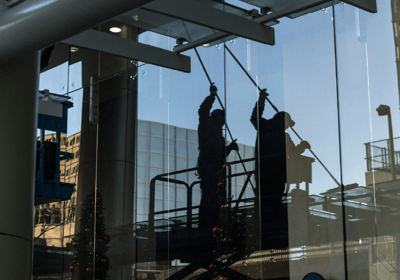 Persona limpiando un vidrio de un edificio.