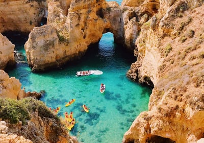 a boat in the water near a cliff
