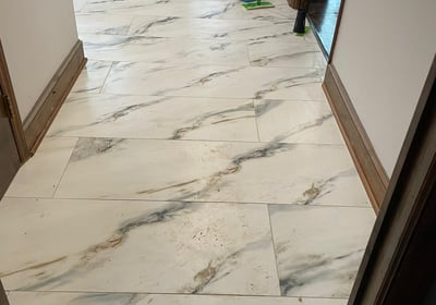 a hallway with a marble floor and a mop