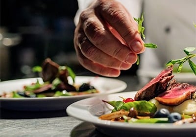 un chef prépare deux assiettes de salade