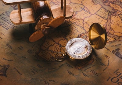 a pocket watch with a compass on a map