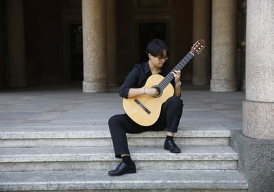 a woman sitting on steps with a guitar