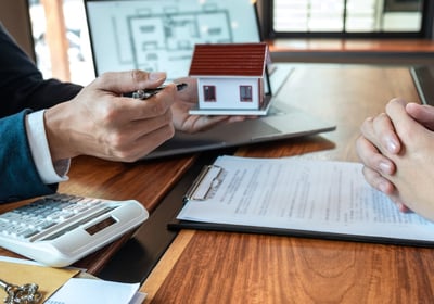 A Realtor sitting at a desk with a Seller explaining his expert services