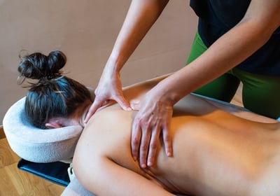 Massage du dos avec les pouces femme allongée sur le ventre