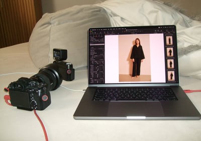 a laptop computer and a camera on a bed