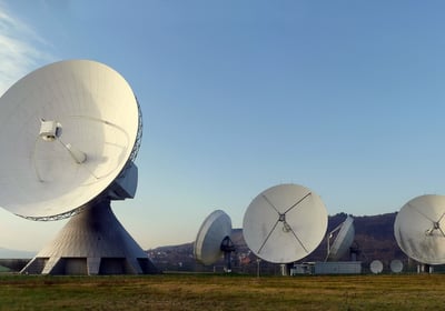 a group of satellite sitting in a field