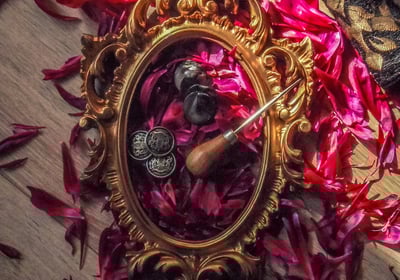 Cadre doré sur pétales de fleurs avec plusieurs outils de couture pour faire des costumes fait main