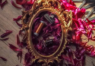 Cadre doré sur pétales de fleurs avec plusieurs outils de couture pour faire des costumes fait main