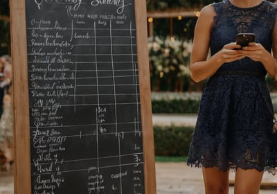 a woman in a short dress standing next to a chalkboard