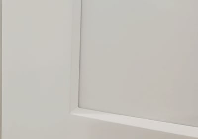 Close-up of a white shaker cabinet door showing smooth painted finish and clean recessed panel — hig
