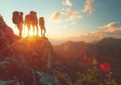 Hikers-standing-on-mountain-summit-at-sunset