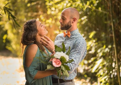 a man and woman standing in front of a tree