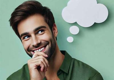 Smiling man in a thoughtful pose, symbolizing the power of positive thinking and affirmations for personal growth and happine